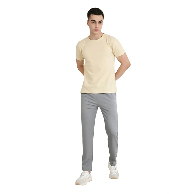 Male model in cream round-neck t-shirt with grey track pants and white sneakers - menswear ecommerce photography by Lohar Studio Delhi